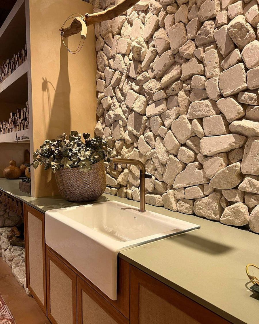 Banheiro com parede de pedra branca, tendência de decoração 2023.