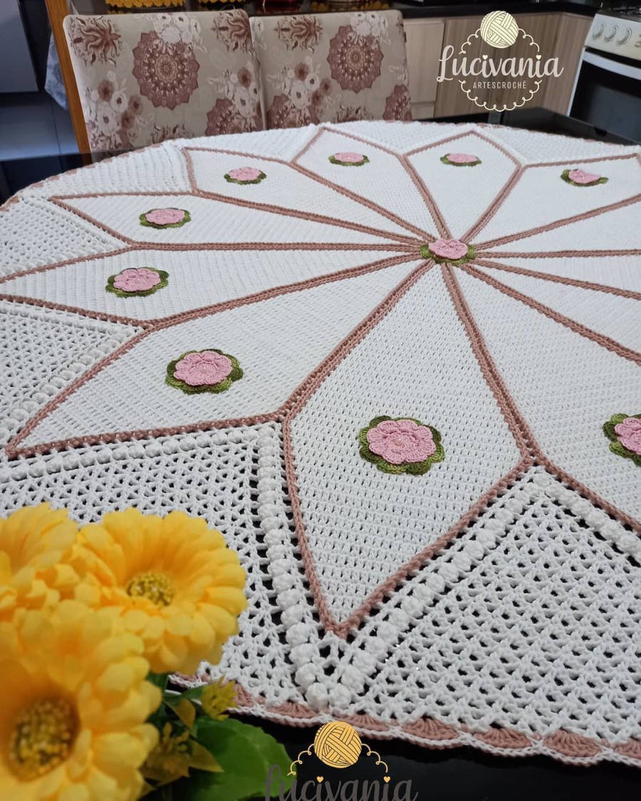 Toalha de mesa de crochê com estrela e pequenas flores.
