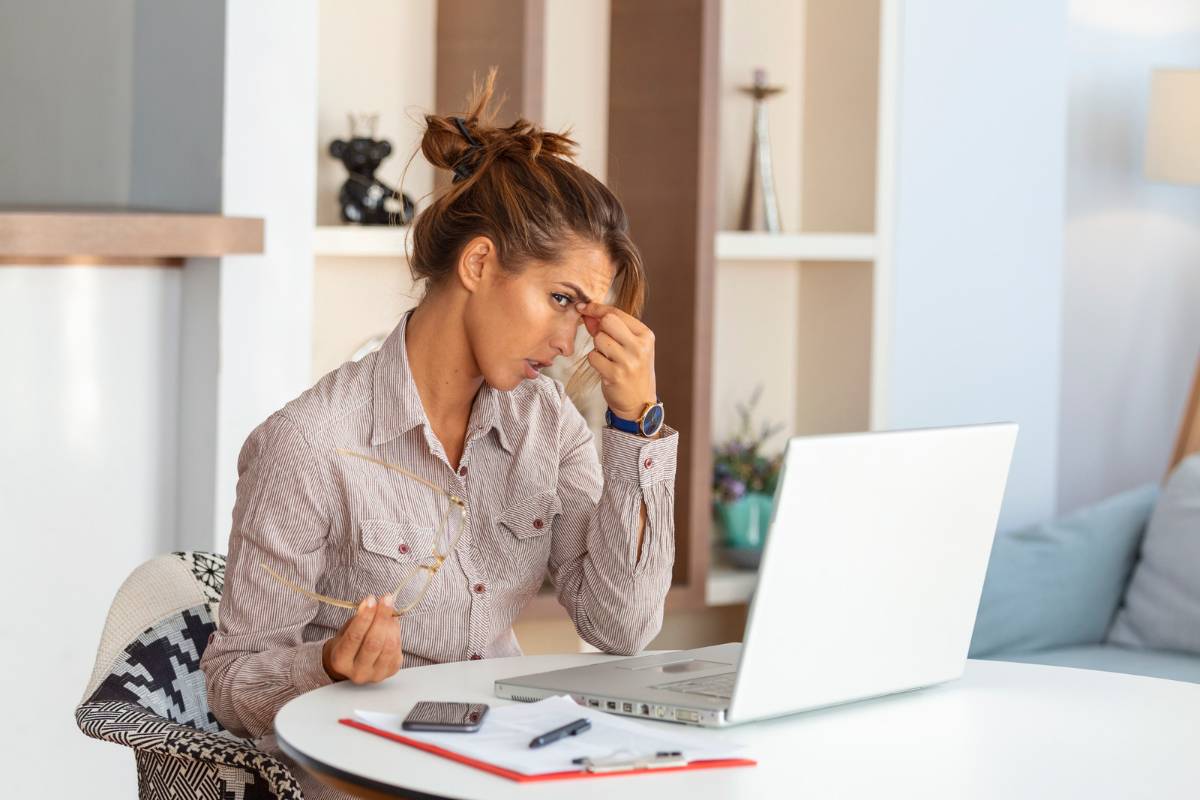 mulher frustrada olhando para a tela de um notebook após apagar fotos do computador