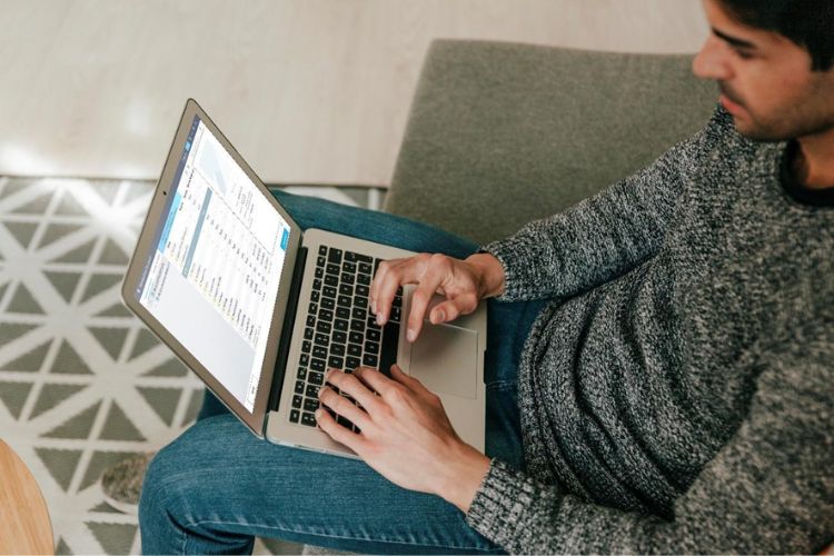 homem usando notebook com Recoverit, programa que recupera fotos do computador que foram excluídas