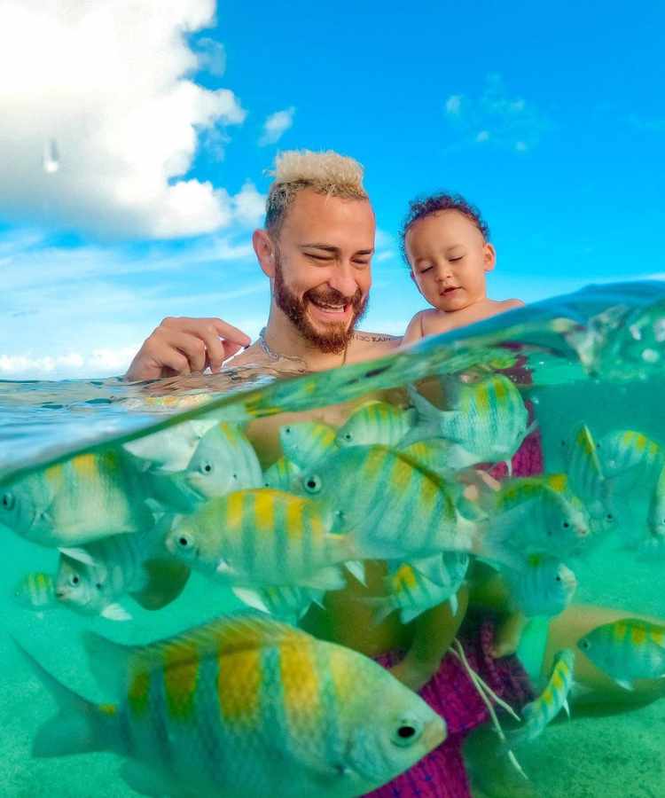 Brother do BBB 23 e apresentador do Desimpedidos com seu filho no mar com peixinhos.