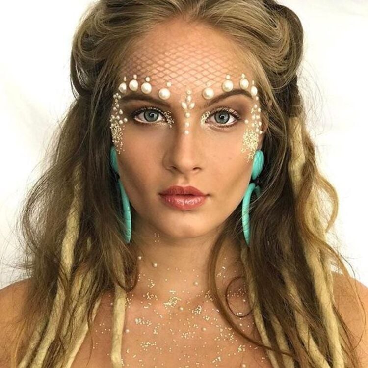 Mulher de perfil com maquiagem de sereia com glitter para o carnaval de 2024