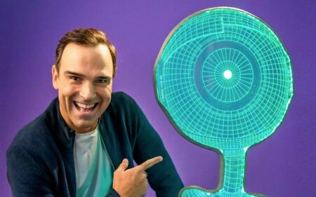 Foto de Tadeu Schmidt com o robô para ilustrar a matéria sobre Poder Coringa do BBB 23