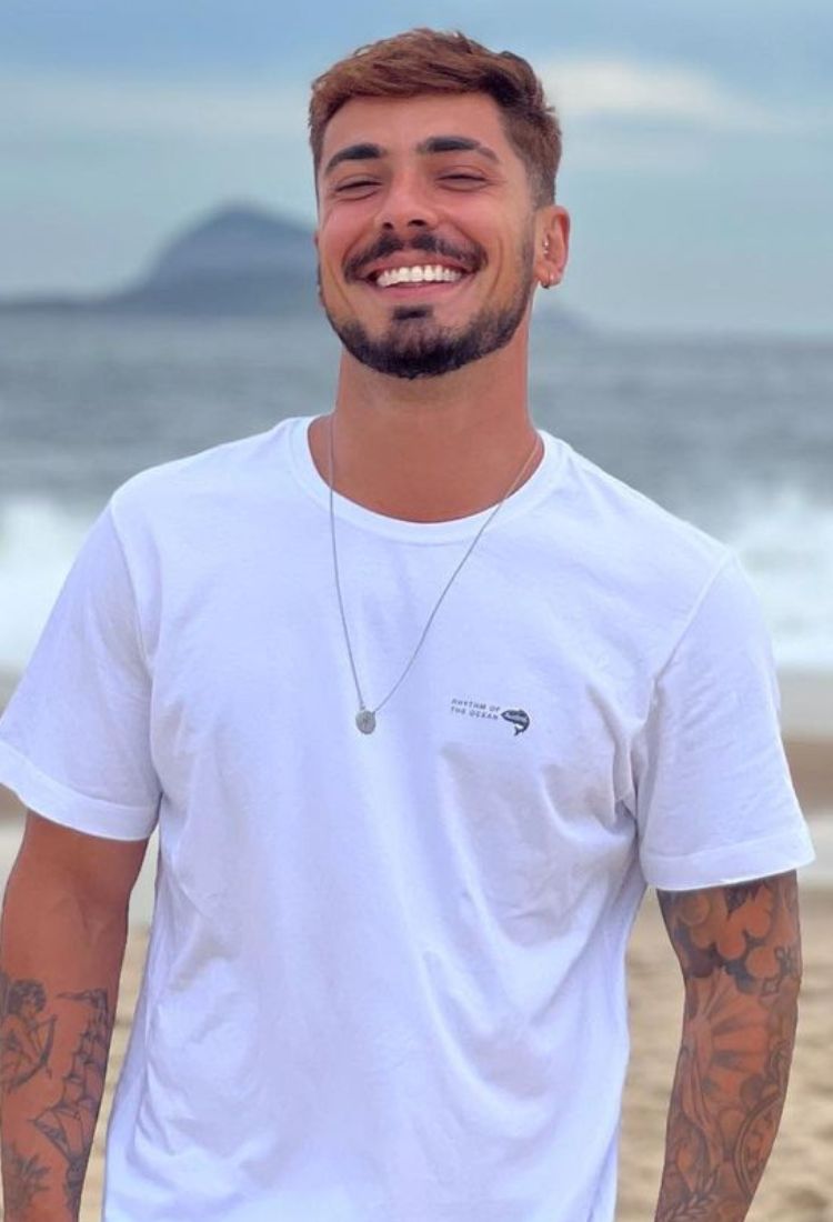 Influenciador digital Rafael Ribeiro sorrindo na praia