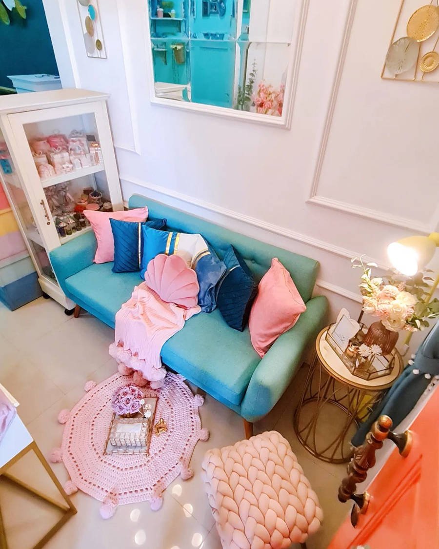 Sala com almofadas azuis e rosa.