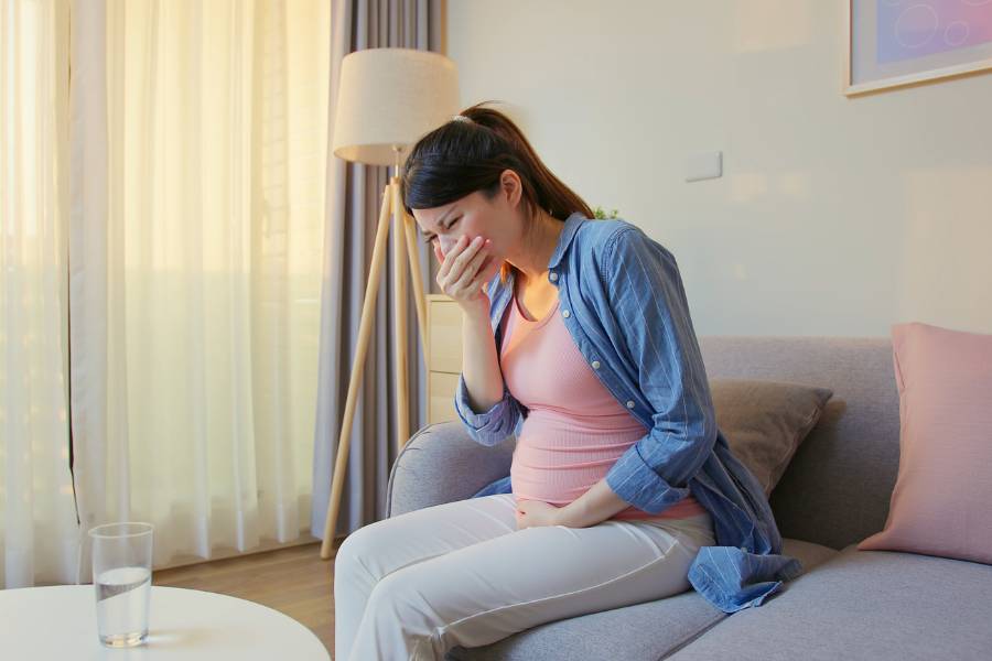 Grávida chorando como um dos sintomas da gravidez.