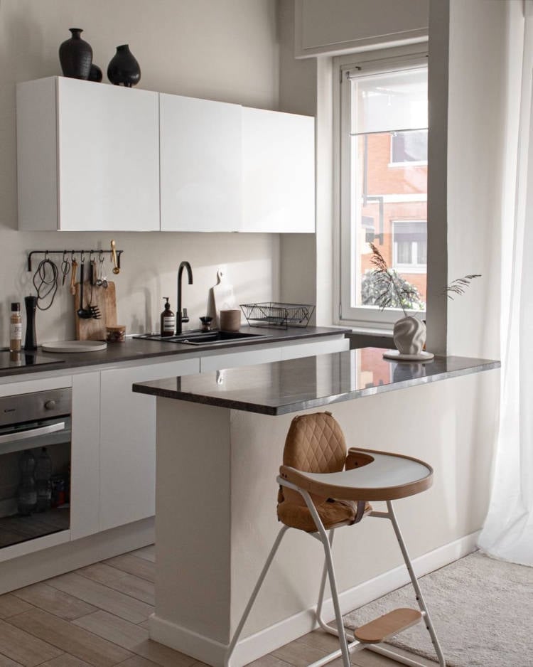 Cozinha de apartamento com móveis brancos.