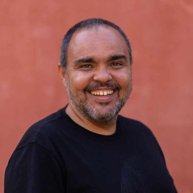 Cristiano Medeiros, gerente de sustentabilidade da Dafiti, sorrindo e usando camiseta preta.
