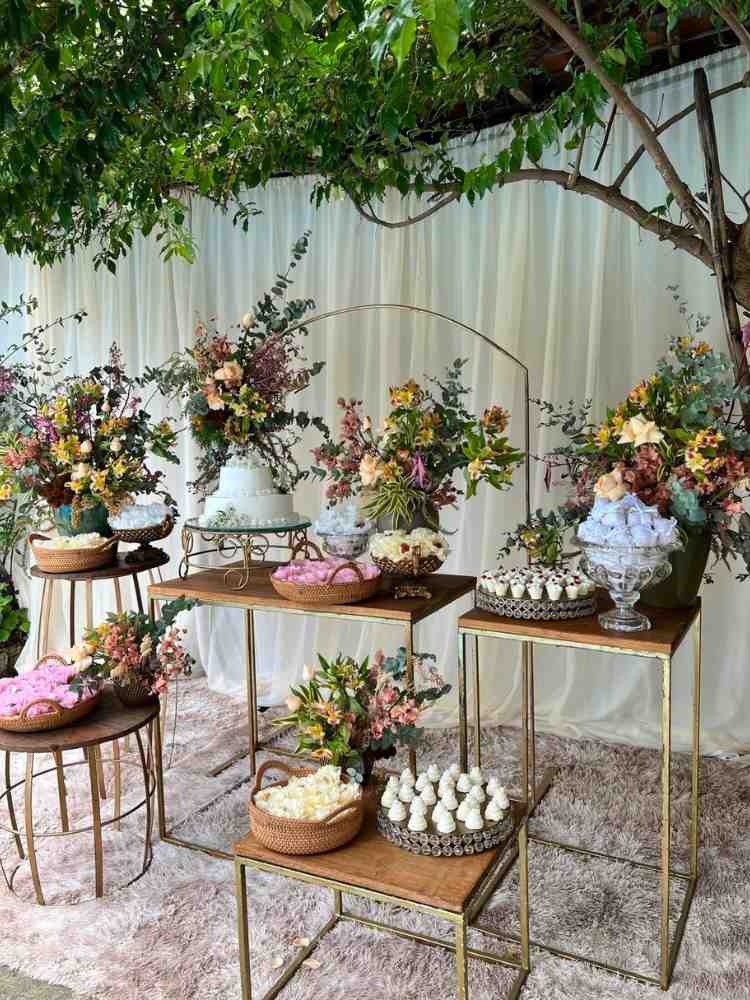 Decoração de mesa de bolo de casamento civil com doces e flores coloridas.