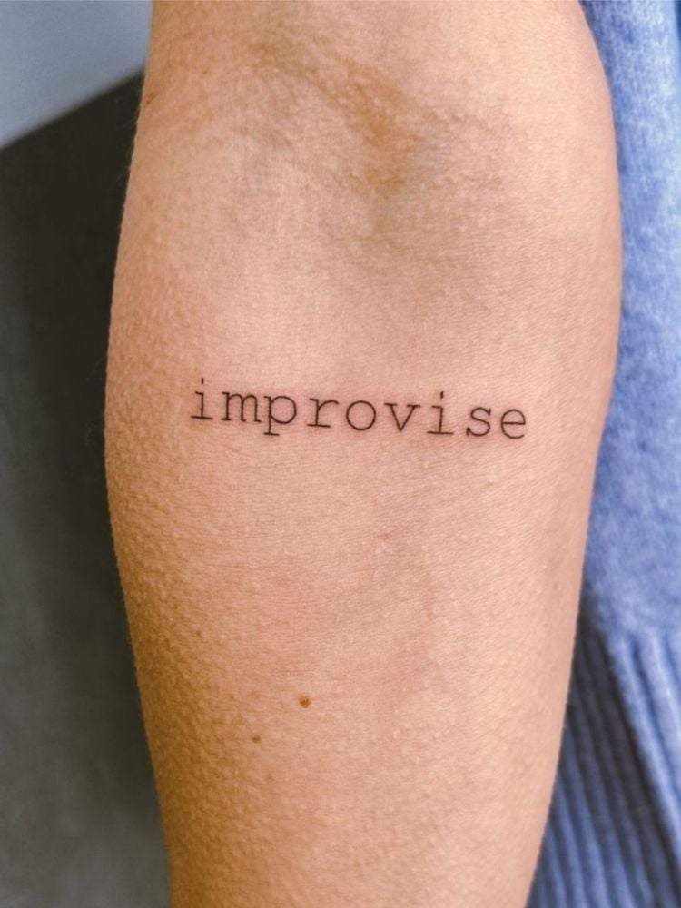 Tatuagem com a palavra improvise.