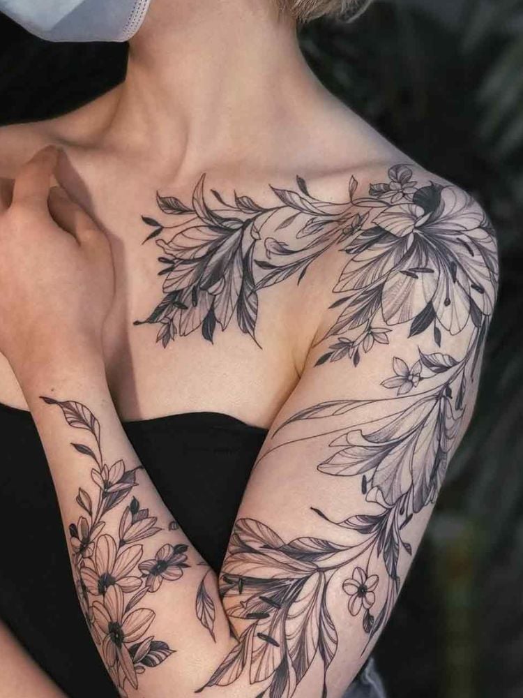 Foto de tatuagem de flores desde o colo até o pulso. 