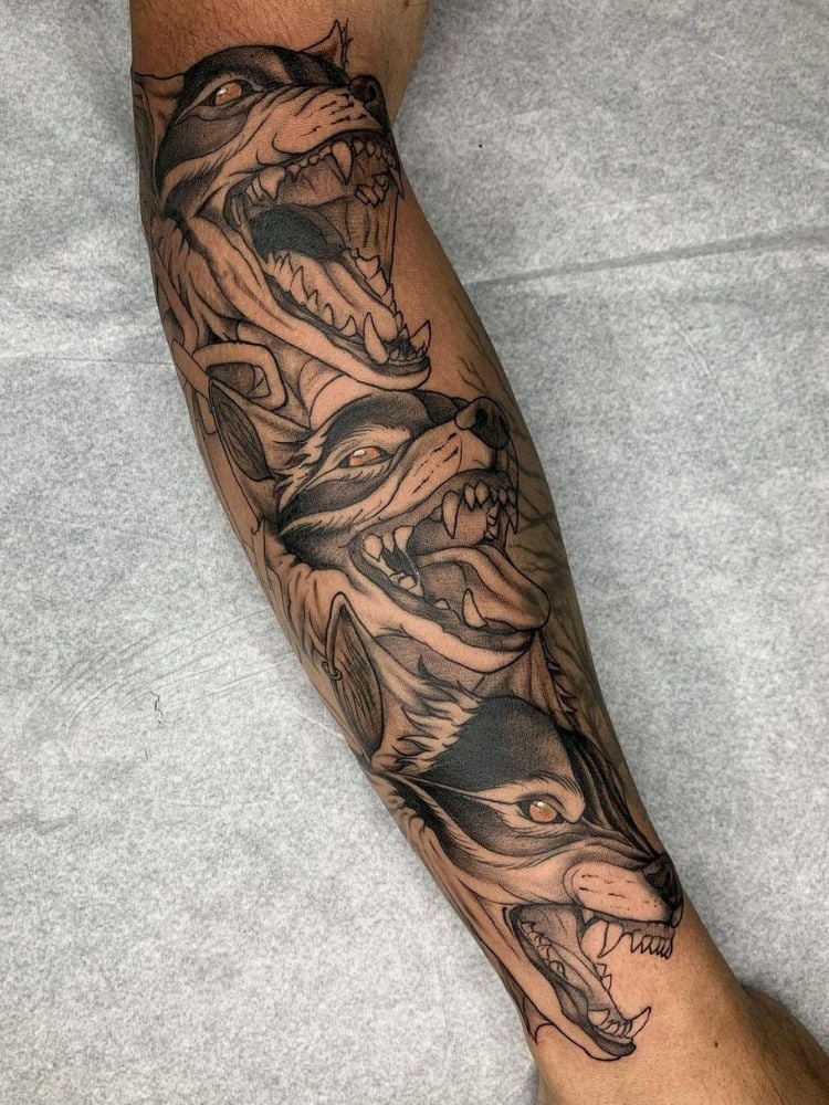 Foto de tatuagem no braço com três lobos. 