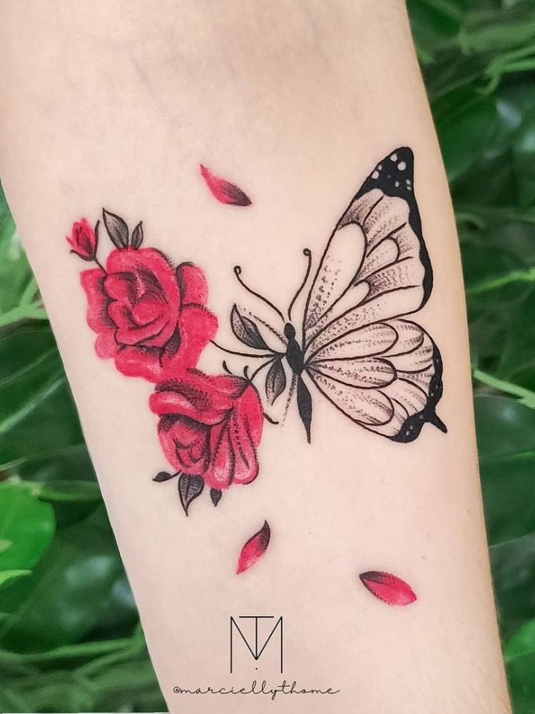 Foto de tatuagem de borboleta e flores no antebraço.