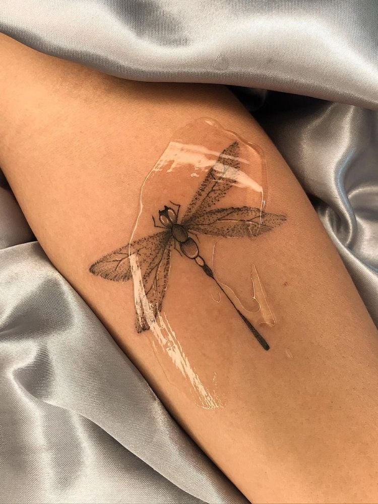 Tatuagem de libélula no antebraço.