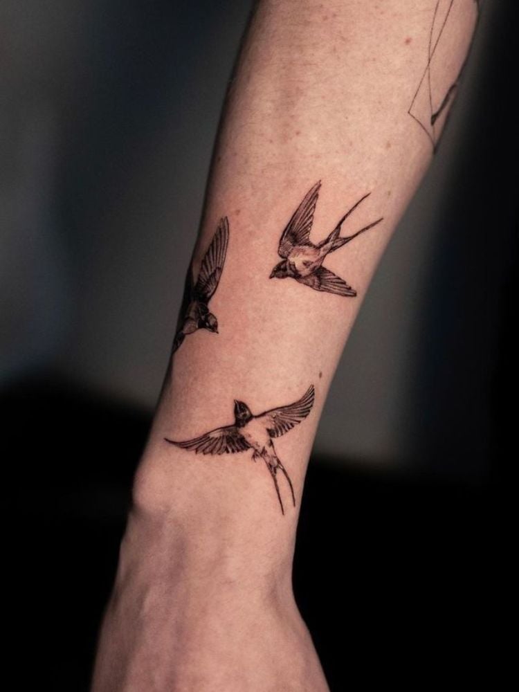 tatuagem de três pássaros feita próximo ao pulso. 