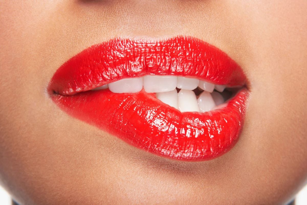 foto de mulher de batom vermelho mordendo os lábios, lado sexy dos signos