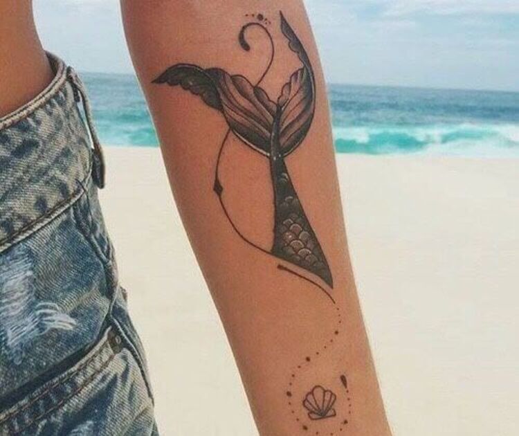 Tatuagem feminina de uma cauda de sereia e uma concha