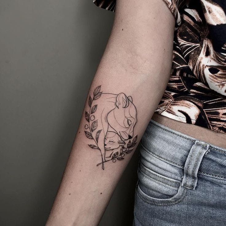 tatuagem de leoa com filhote no antebraço, ramos na parte inferior