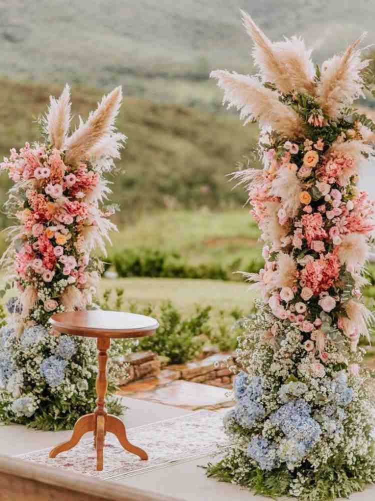 Altar de casamento maximalista com muitas flores rosas e azuis.