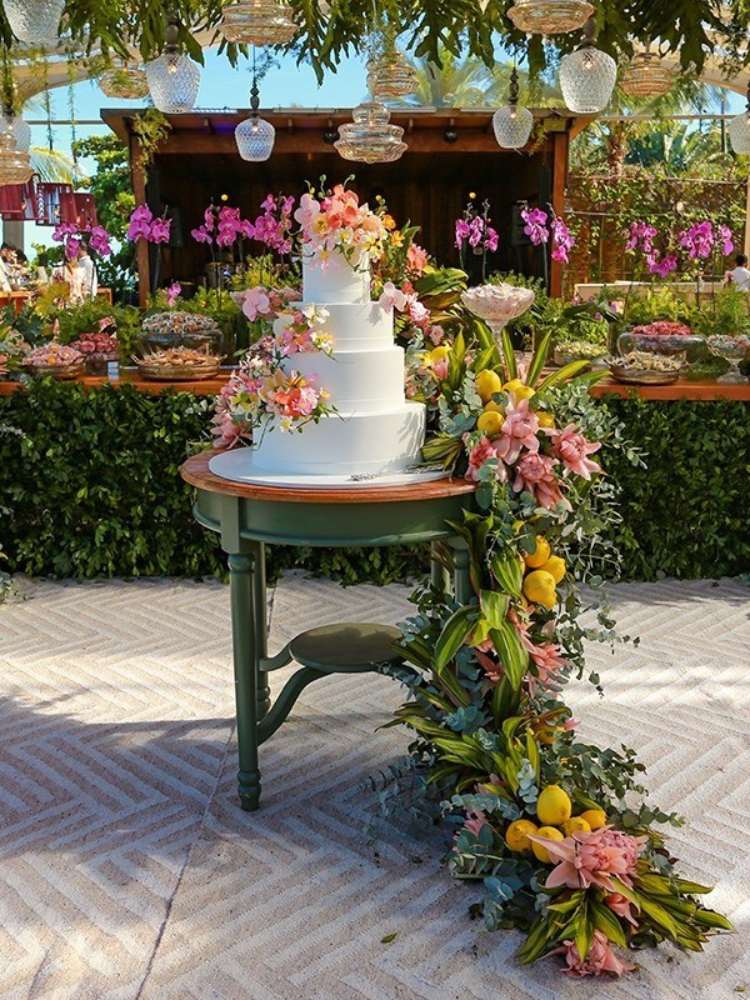 Bolo de casamento decorado com flores e frutas.