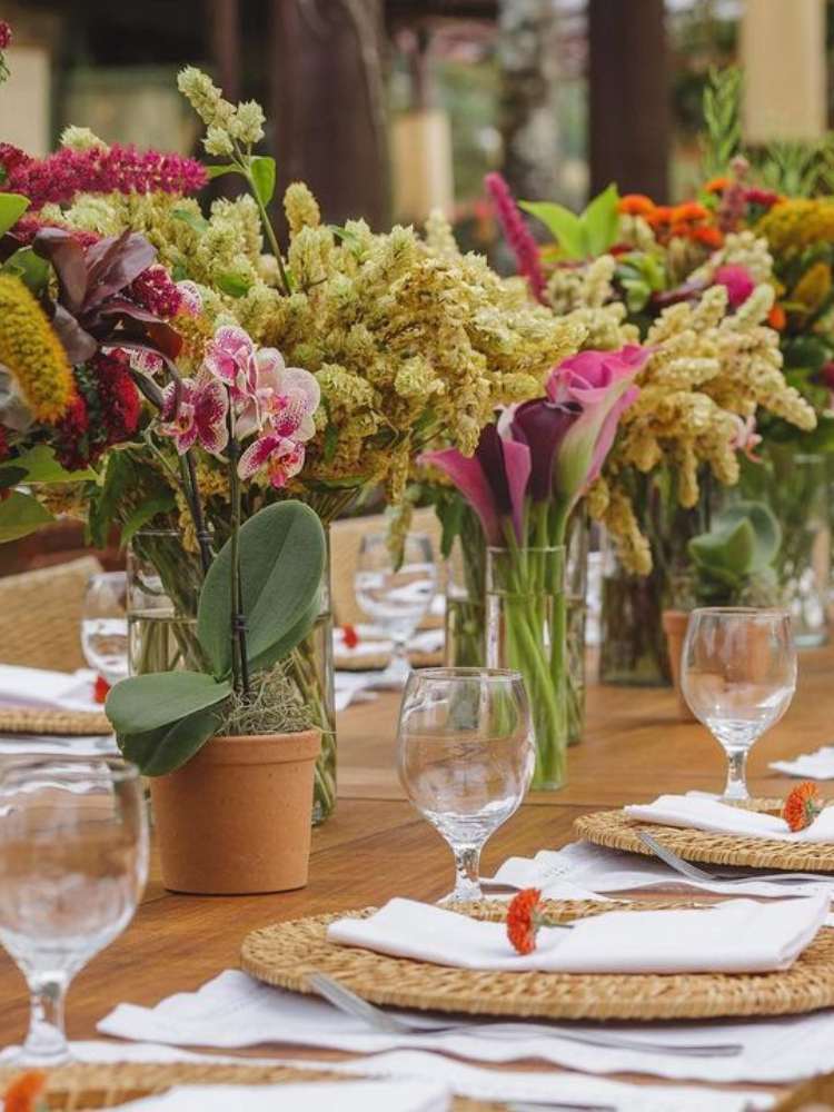 Decoração de mesa casamento com pote de barro e flores.