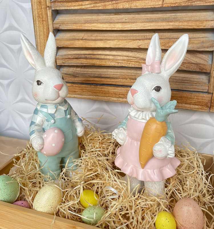 Casal de coelhos em resina, em caixa com ovos coloridos de Páscoa.