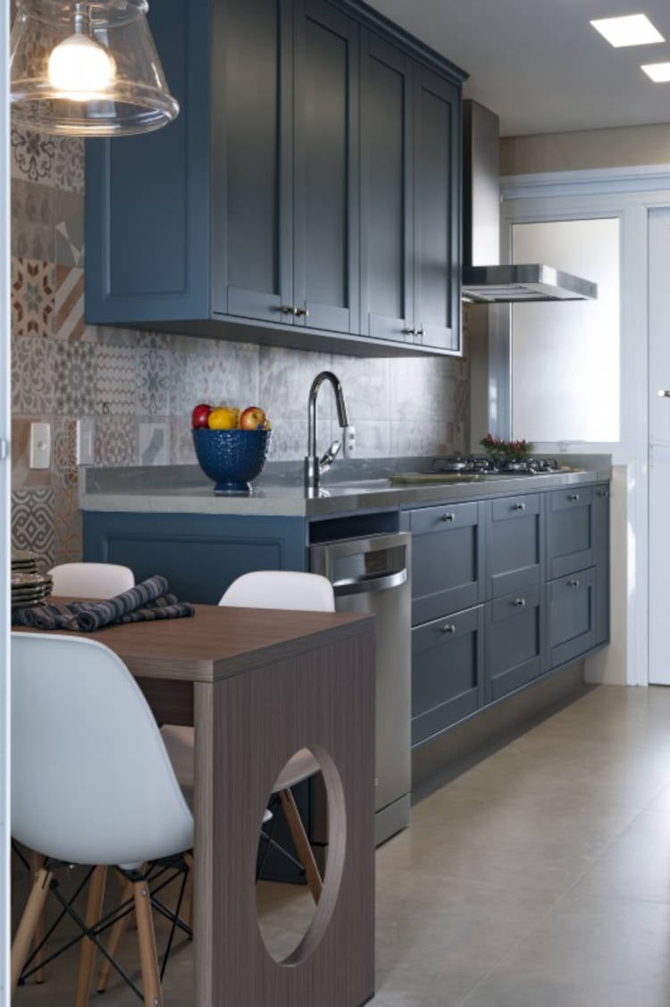 Cozinha pequena com revestimento de azulejos e armário azul.