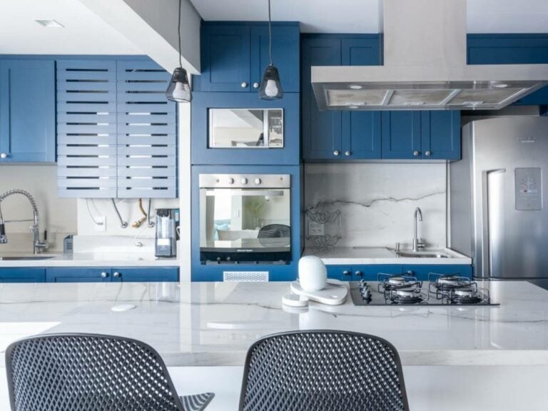 Cozinha azul com revestimento branco.