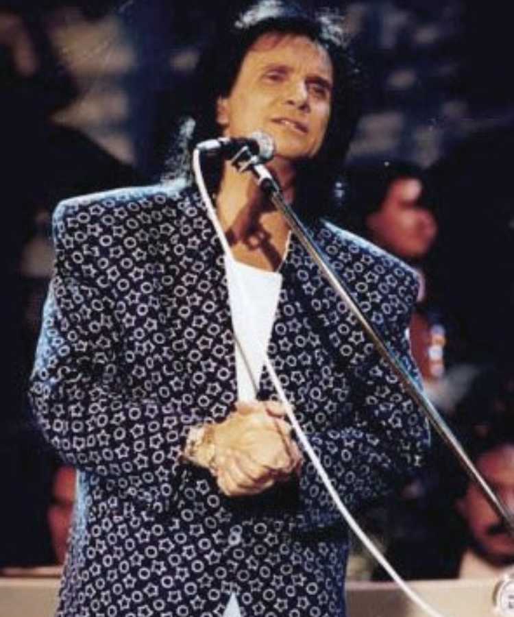 Foto antiga do cantor cantando em show.