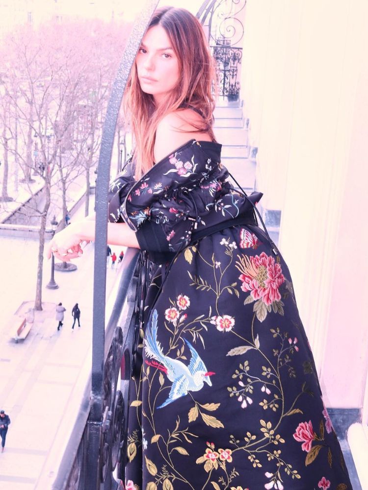 foto da atriz isis valverde usando vestido longo preto com flores, para a paris fashion week 2023. 
