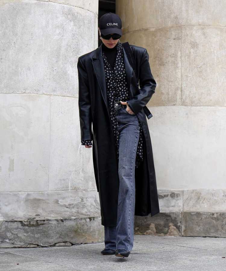 Mulher com looks tendência para Outono Inverno 2024: vestido sob calça + sorbetudo de couro preto + calça skinne.