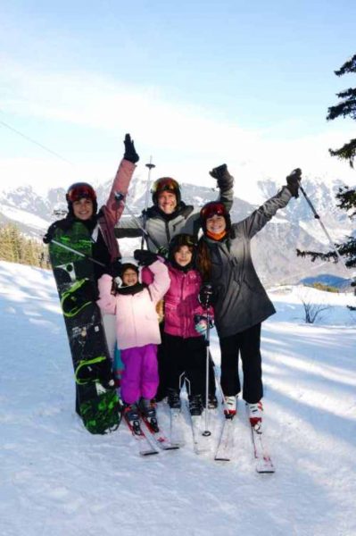 família de Kyra indo esquiar em montanha 