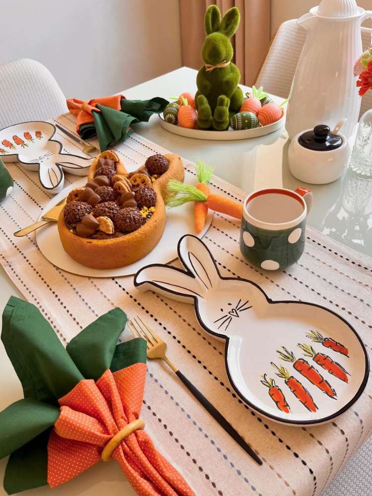 Mesa posta de páscoa com guardanapo de cenoura, prato em formato de coelho, bolo em formato de coelho, enfeite de coelho com ovos e mais!