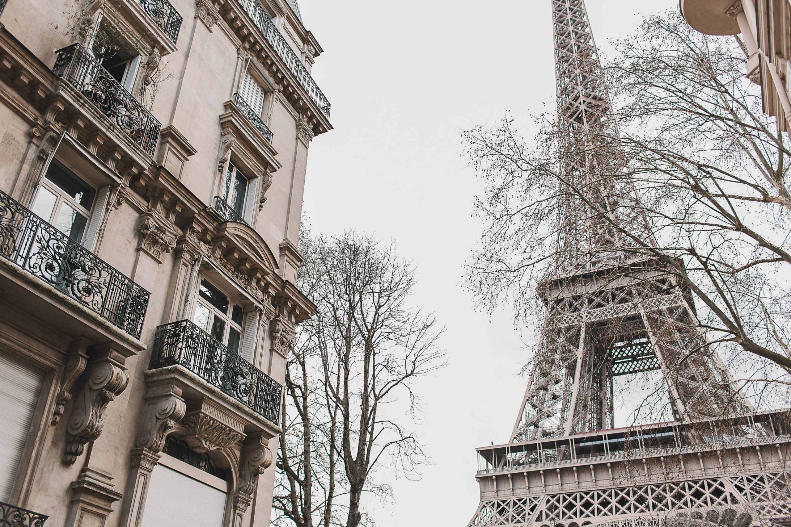 Torre Eiffel do lado de um prédio com arquitetura tradicional e antiga