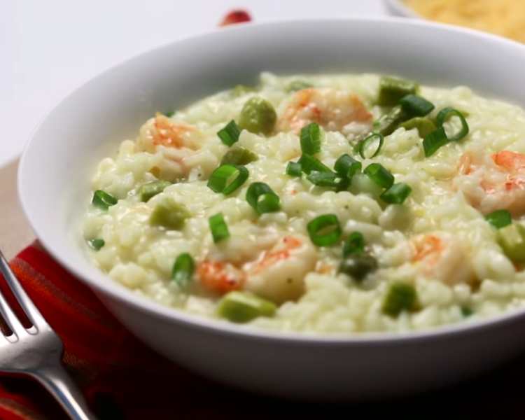 Prato de risoto de camarão com aspargos.