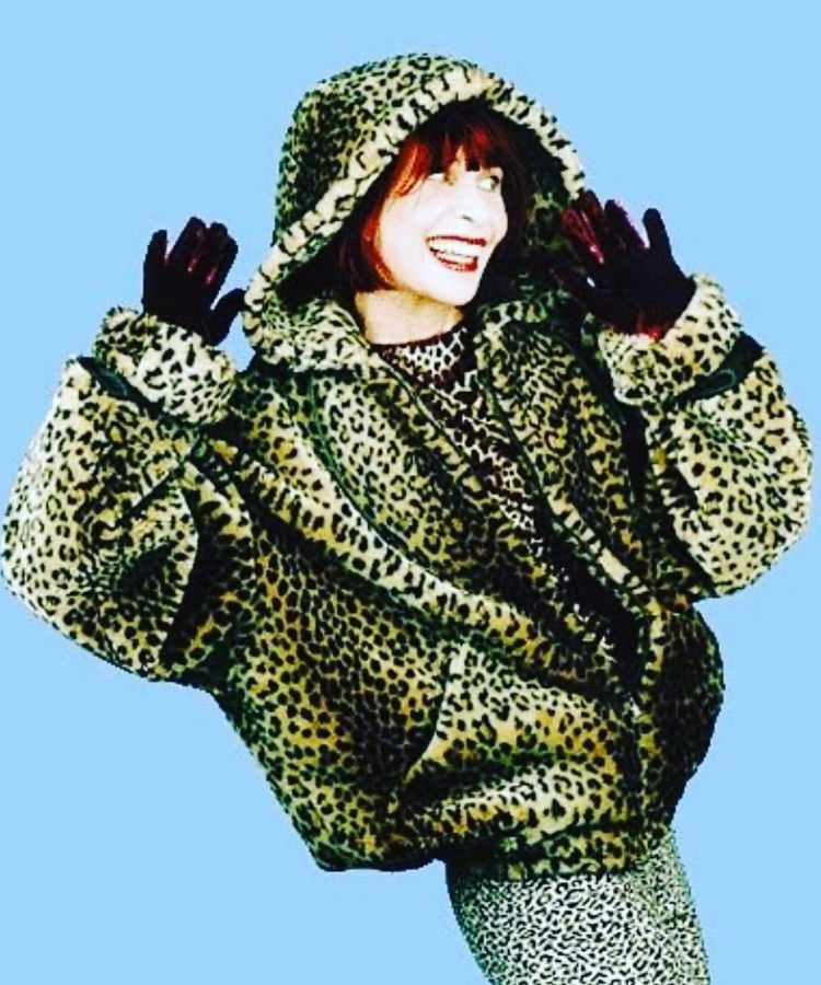 Cantora Rita Lee jovem usando casaco peludo com estampa de oncinha.