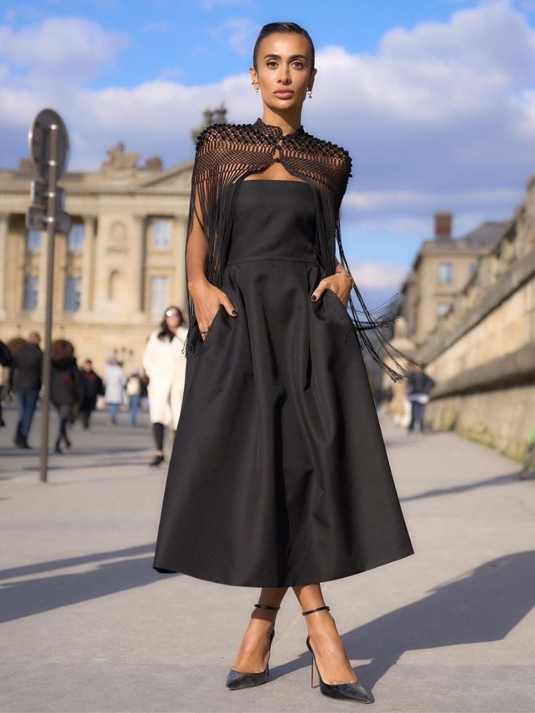 foto de influencer silvia braz na paris fashion week, com vestido midi preto, com detalhes no busto e nos ombros. 