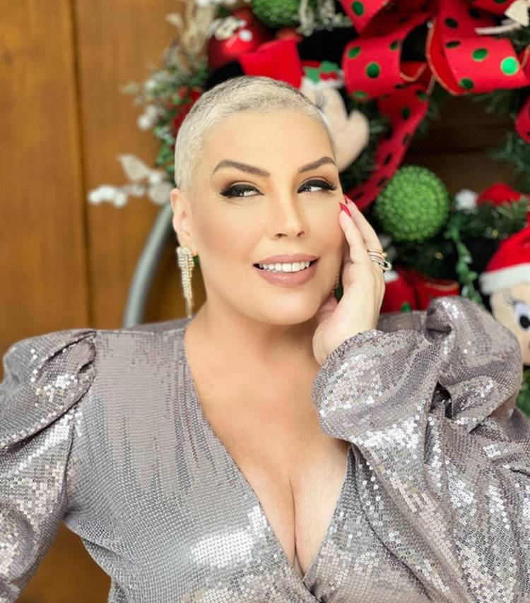 Simony, a talentosa cantora brasileira, brilha em um look prata reluzente e cabelo curto raspado, em uma foto natalina que transmite alegria e elegância.