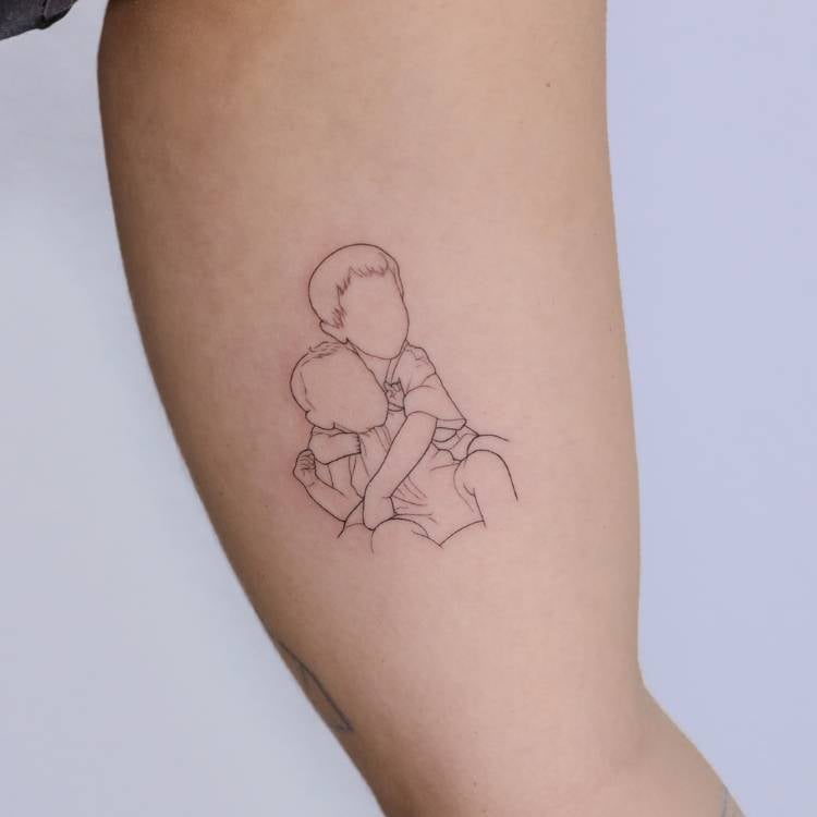Tatuagem femimina no interior do braço, cujo desenho é o contorno de uma foto de duas crianças abraçadas. 