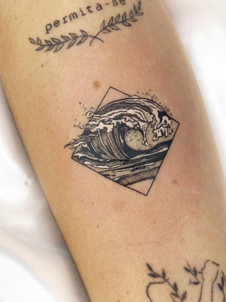 Tatuagem de onda no braço, realista e dentro de um losango