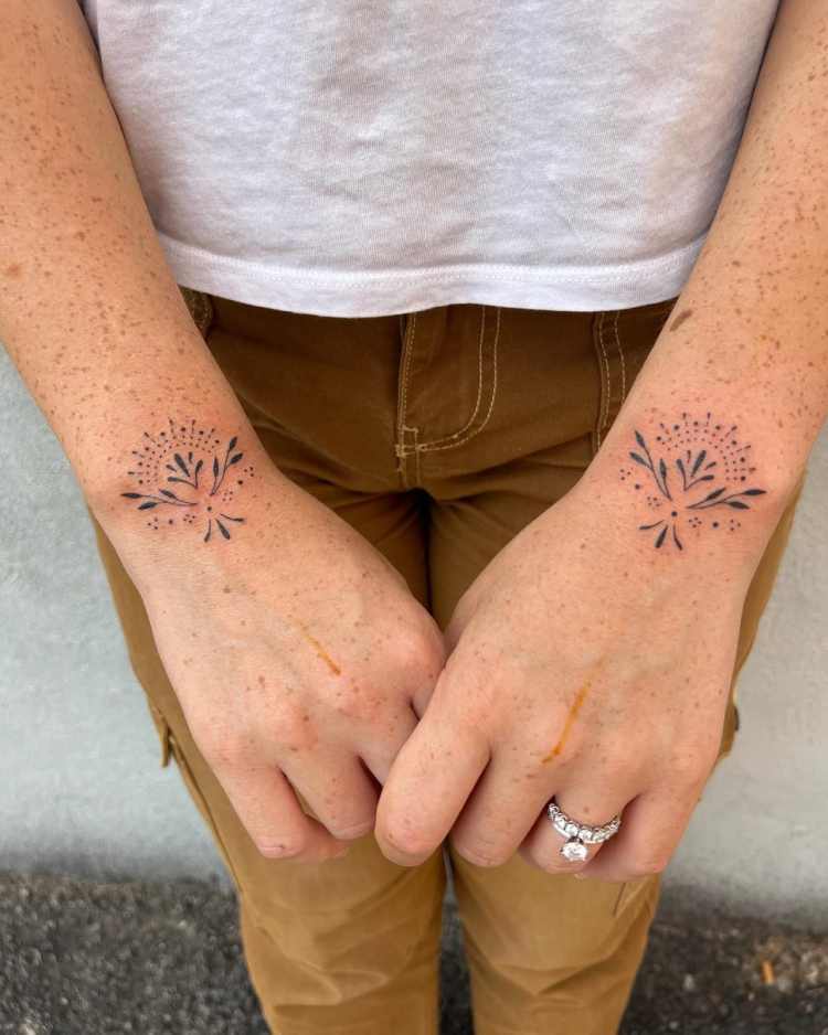 tatuagem nos dois pulsos na parte superior, estilo ornamental de linhas finas