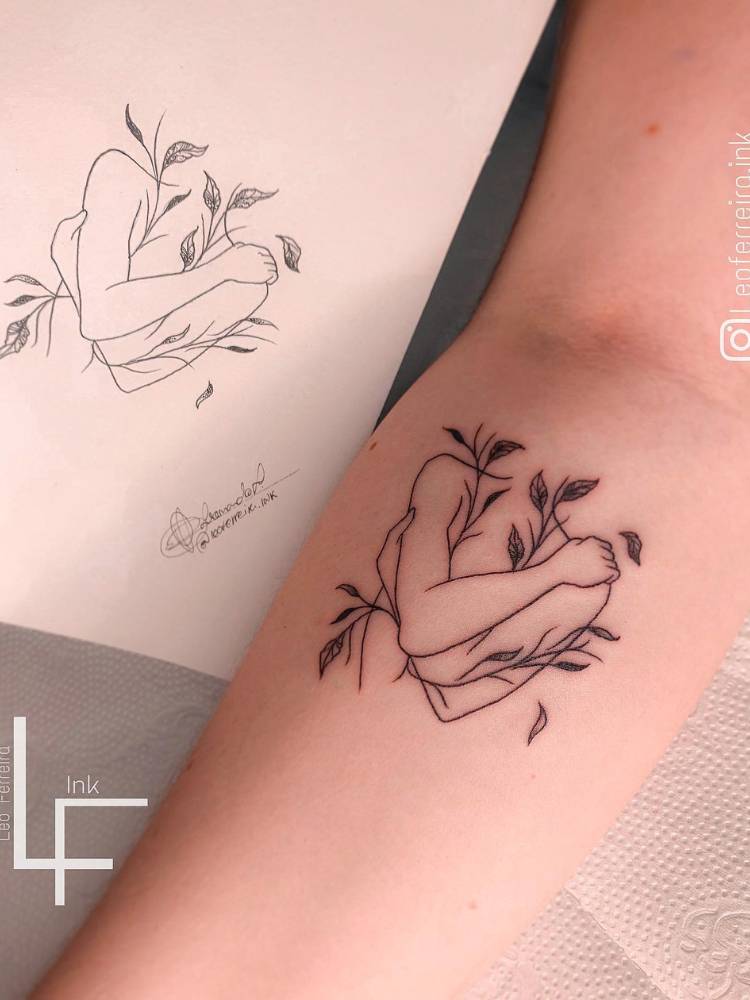 Tatuagem de silhueta se abraçando, com alguns ramos em volta. 