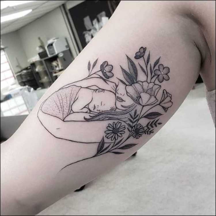 tatuagem mãe segurando recém-nascido, flores ao redor