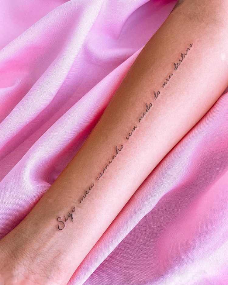 tatuagem no pulso escrito "sigo meu caminho sem medo do meu destino"