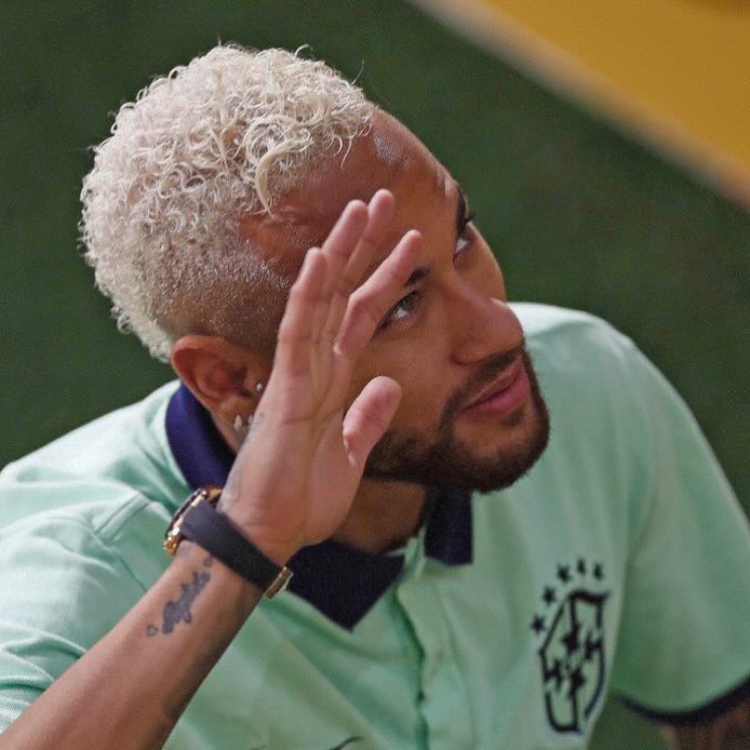 Neymar Jr. com camisa polo da seleção brasileira acenando
