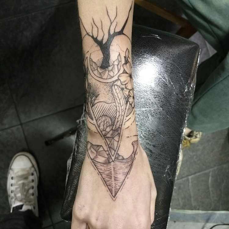 tatuagem no braço com elementos da natureza, mar, árvore, lua e plantas