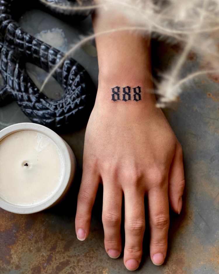 tatuagem número 888 na parte superior do pulso