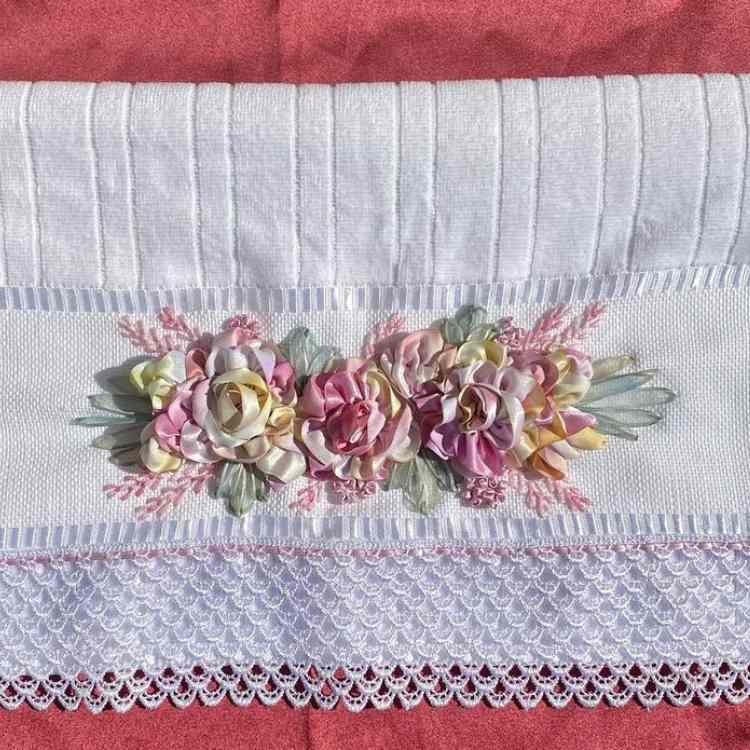 toalha de banho ou de rosto que foi bordada à mão com flores de cetim cores tie-dye