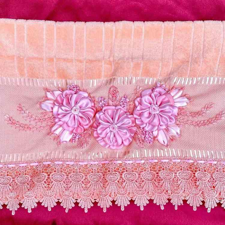 toalha de banho ou de rosto que foi bordada à mão com flores de cetim cor-de-rosa.
