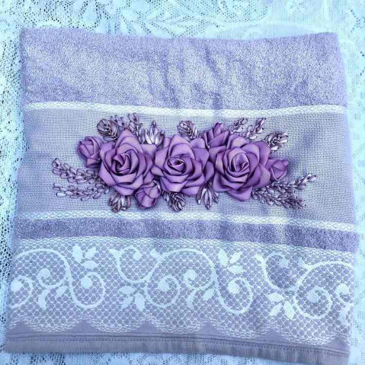 toalha de banho ou de rosto que foi bordada à mão com flores-de-cetim lilás